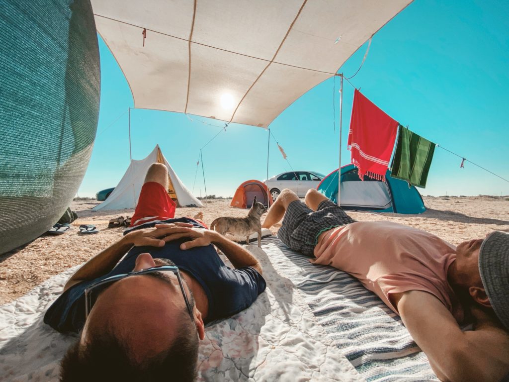 Two men chilling in camp on the beach